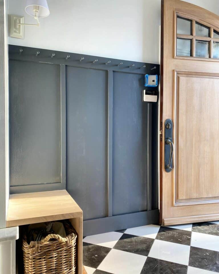 Black and White Tiled Mudroom With Arched Wood Door
