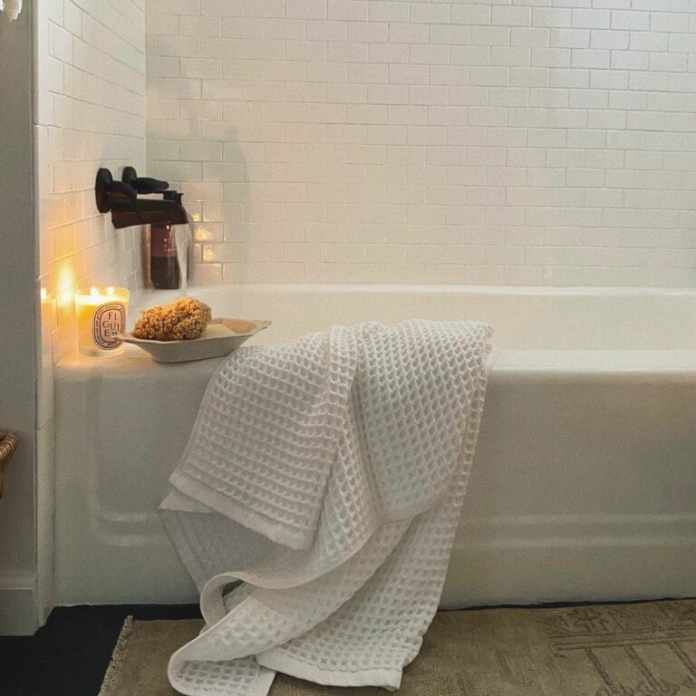 Warm Candlelight Shines on White Tile