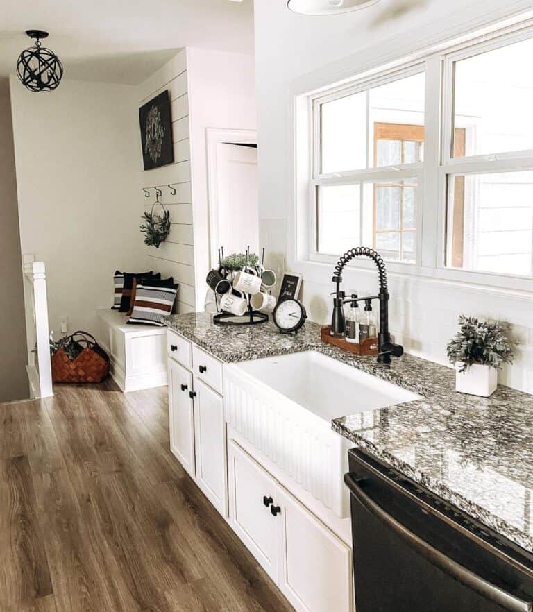 Bright Windows Above White Shiplap Backsplash with Busy Granite Countertops