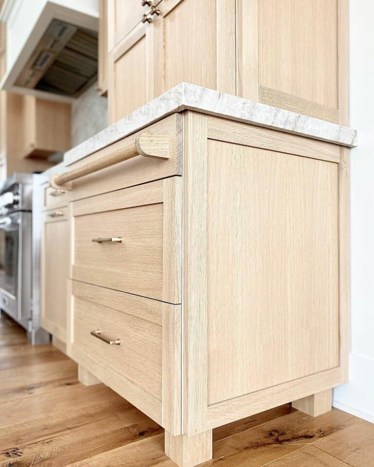 Brass Drawer Pulls Attached to Warm Wood Cabinet