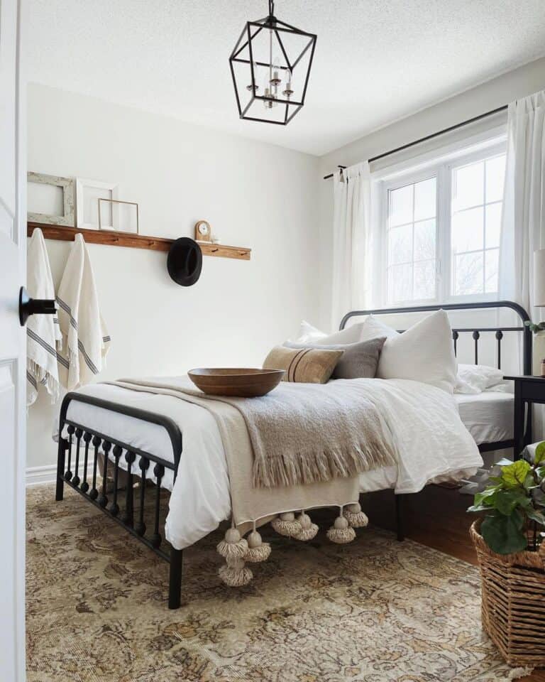 Black Pendant Lantern Light Fixture Over a Black Metal Bed