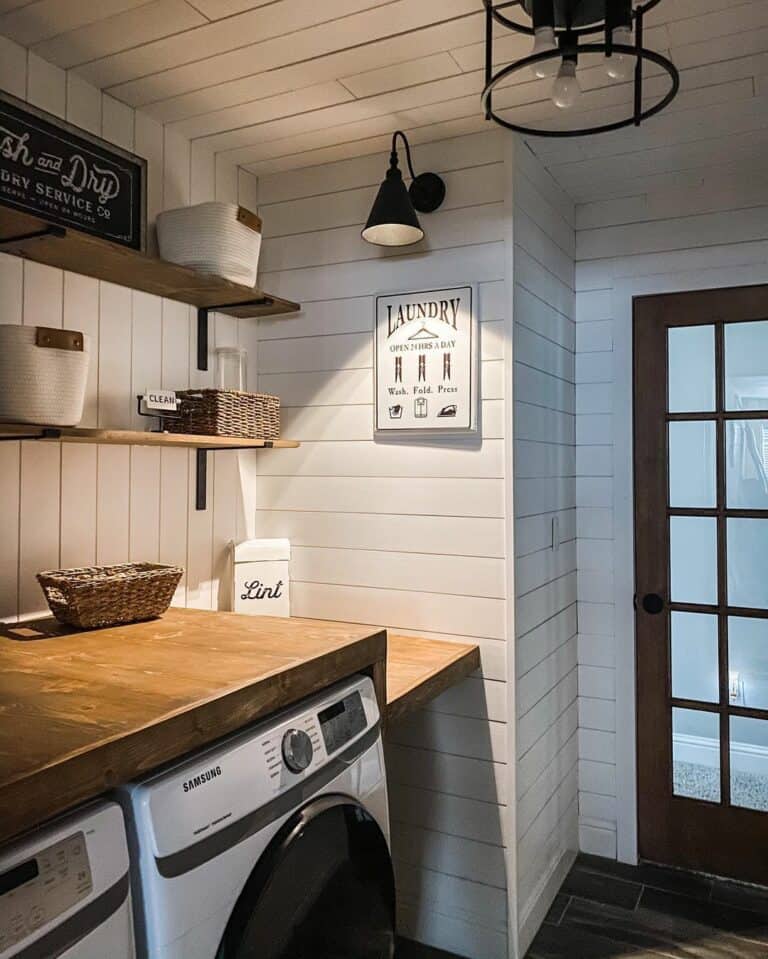 Black Sconce Over a White Laundry Room Sign